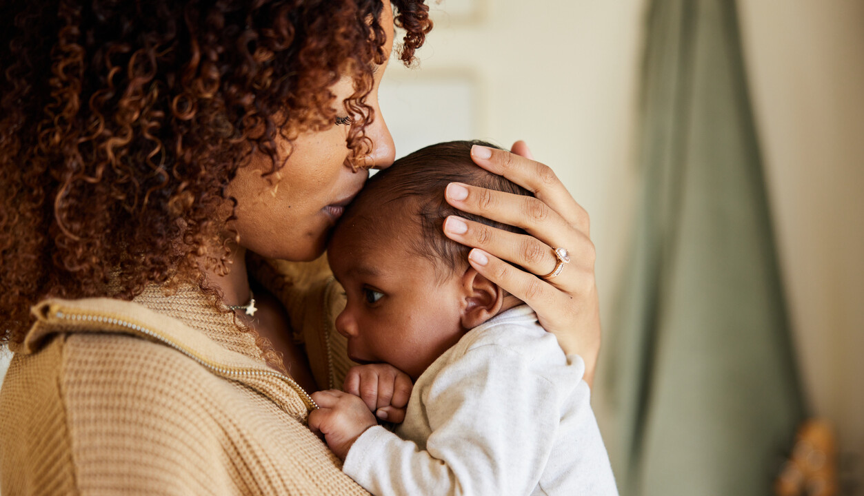 A woman is holding her baby in her arms.